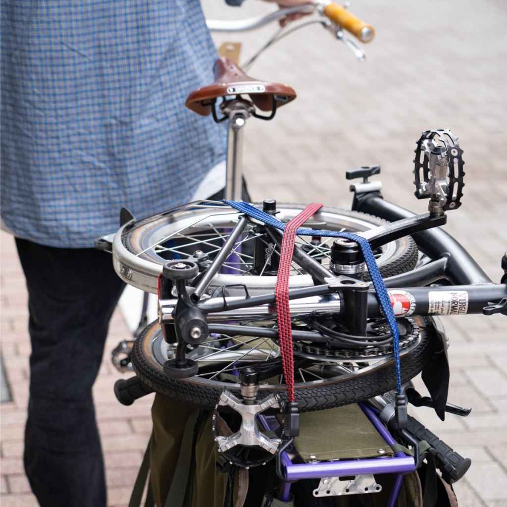 Blue Lug Flat Bungee elastic bicycle cargo strap with steel-structured hooks for securing bags and belongings to bicycle racks and baskets.