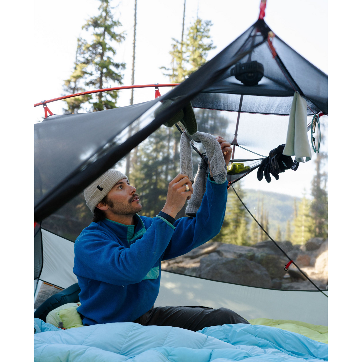 MSR Hubba Hubba LT 1‑Person Tent pitched with someone hanging socks from the gear loft clothesline