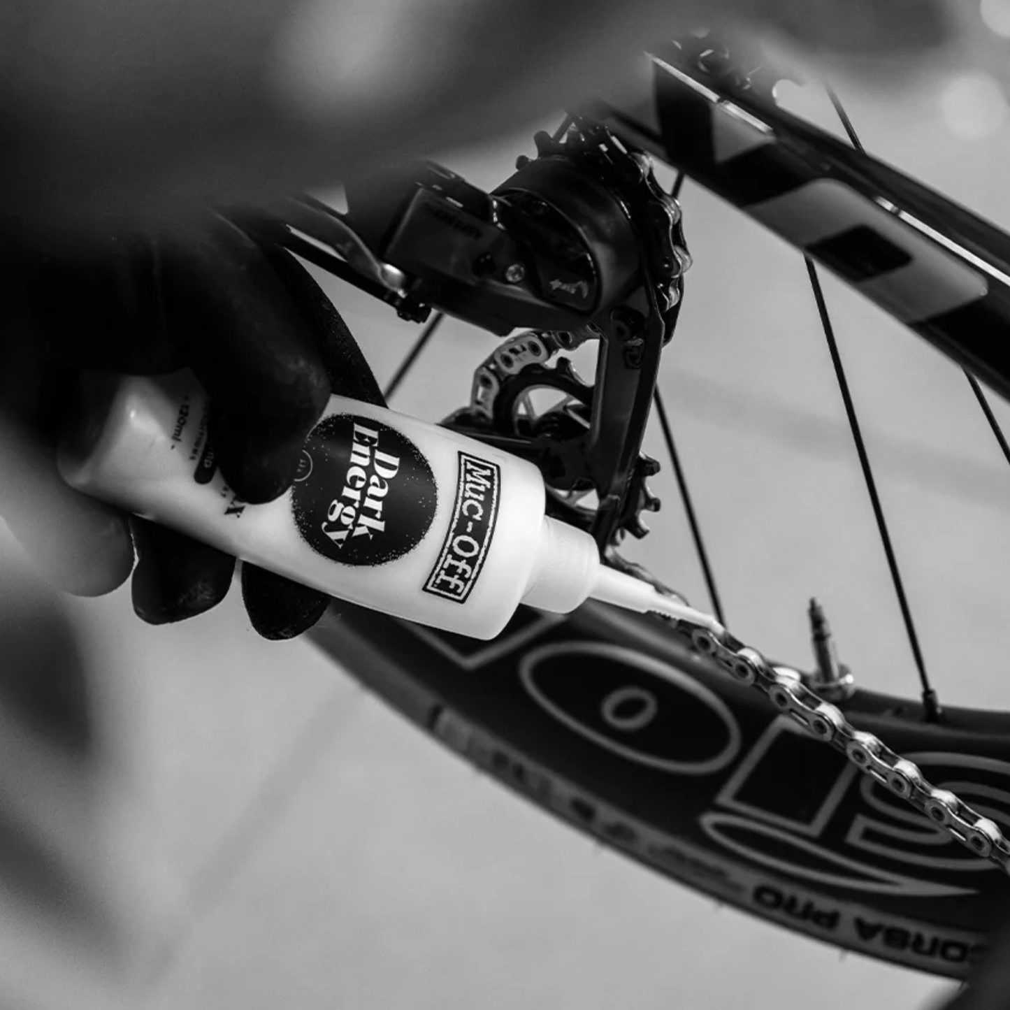 Muc-Off Dark Energy Chain Wax dropper bottle in use on a bike chain
