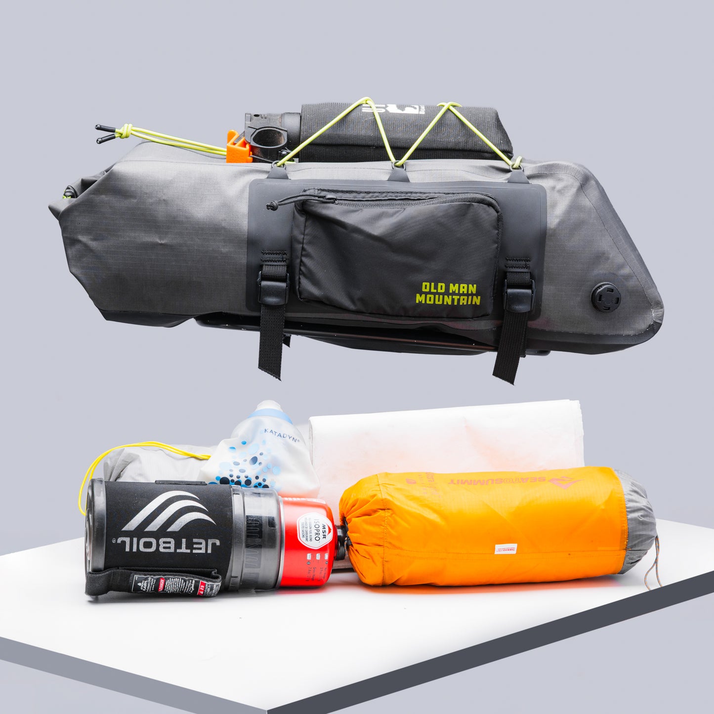 Old Man Mountain Atlas Rack Pack 12L with camping items that would fit the pack