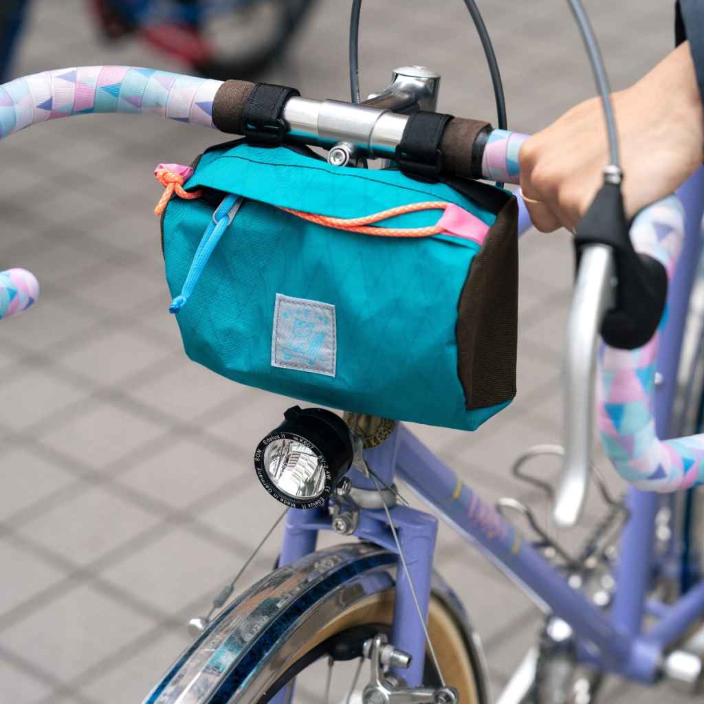 Blue Lug Handlebar Pouch featuring a compact, soft-sided nylon construction with removable straps for mounting to bicycle handlebars.