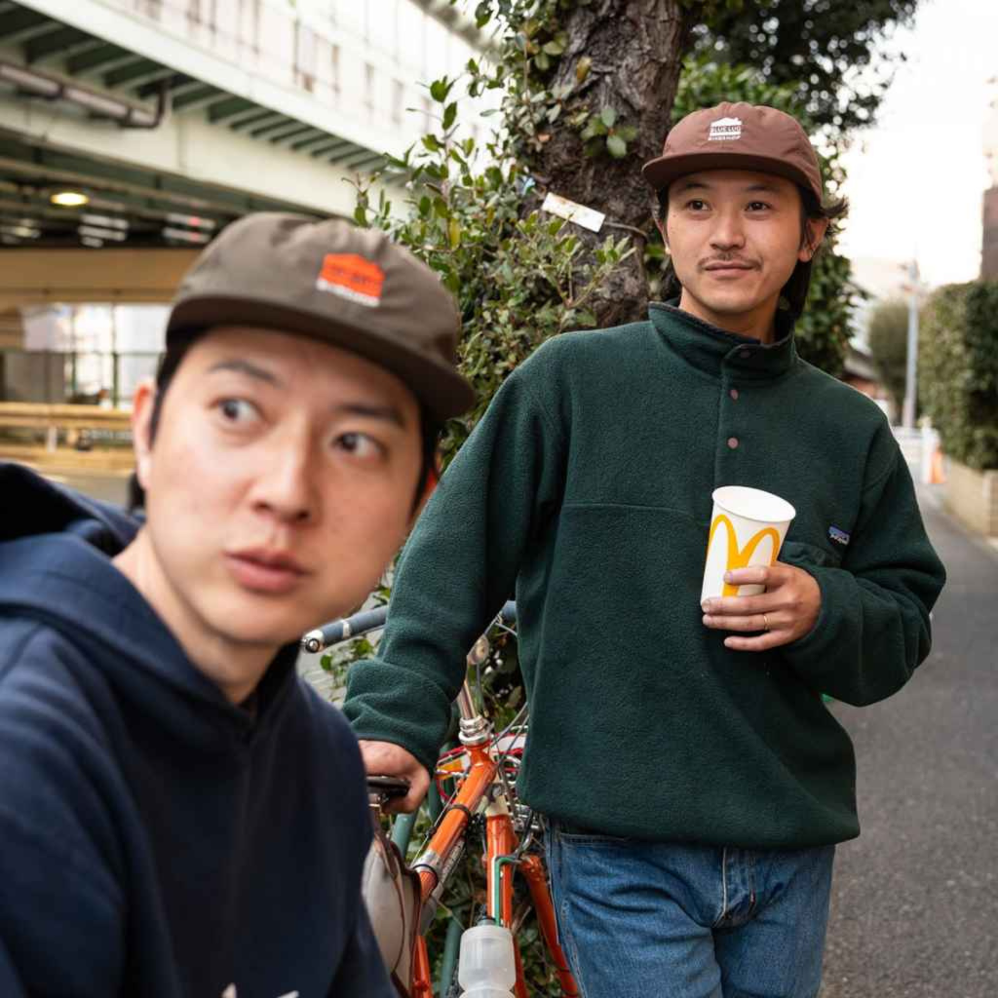 Two men standing outdoors, wearing the Blue Lug House Logo cap