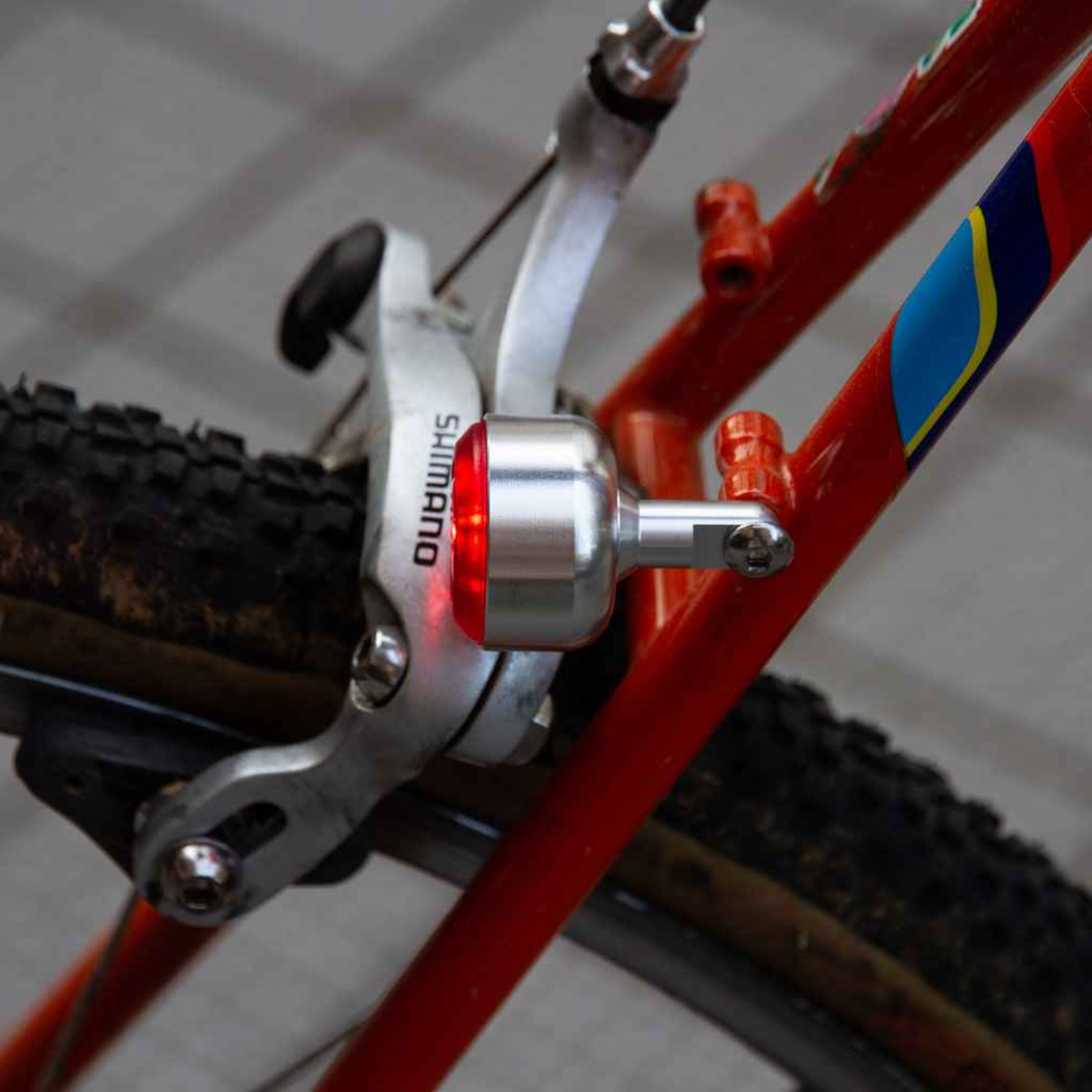 Blue Lug Koma Light Rear compact USB rechargeable bicycle taillight in silver, mounted above rear brake