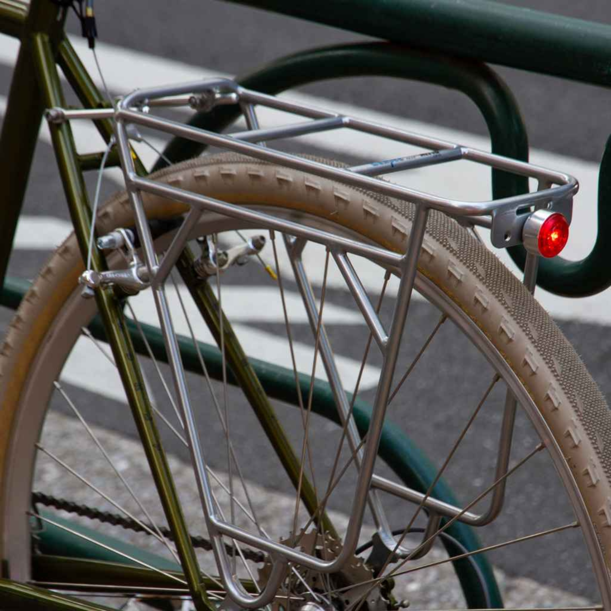 Blue Lug Koma Light Rear compact USB rechargeable bicycle taillight in silver mounted to a rear rack