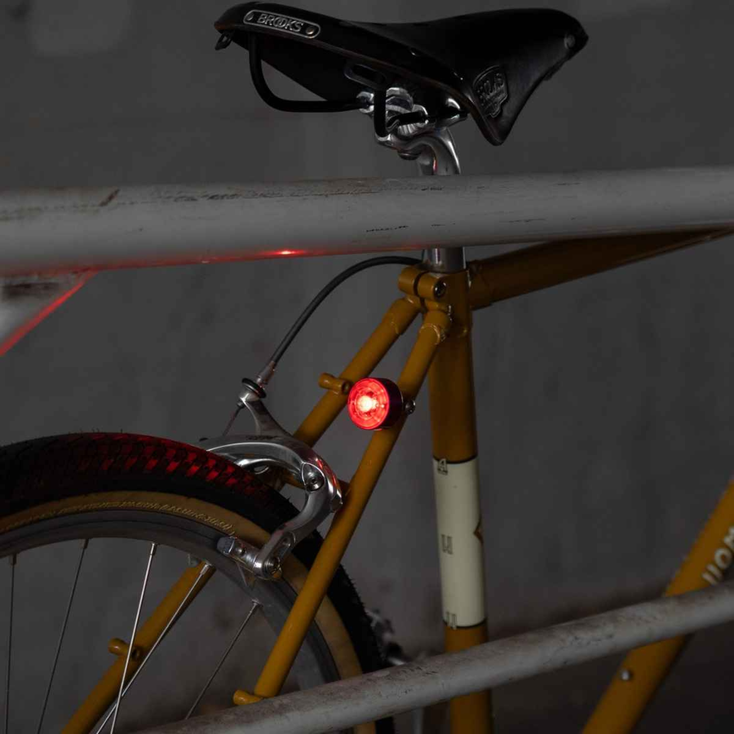Blue Lug Koma Light Rear compact USB rechargeable bicycle taillight in black mounted to a  mustard colour bike