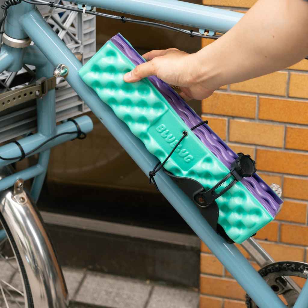 Blue Lug Puff Seat folding foam seat pad in green and purple. Foldable camping seat for on the go and bike rides. Fits Wald basket.