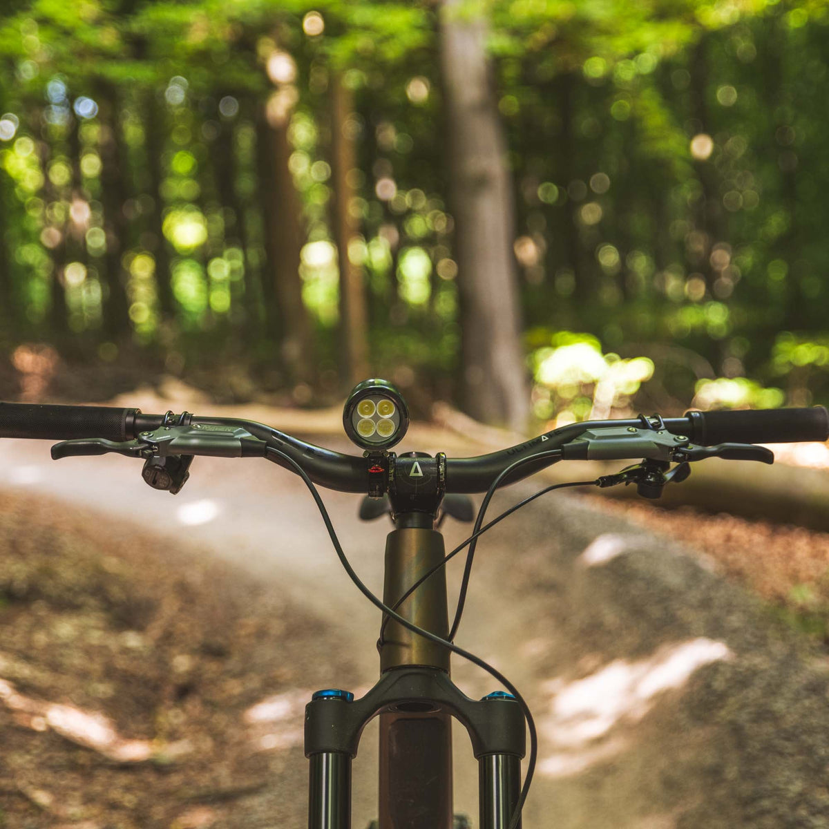 Exposure Lights MaXx-D 17 rechargeable front bicycle light with gunmetal grey CNC-machined aluminium body, 4850-lumen REFLEX output and colour OLED display.