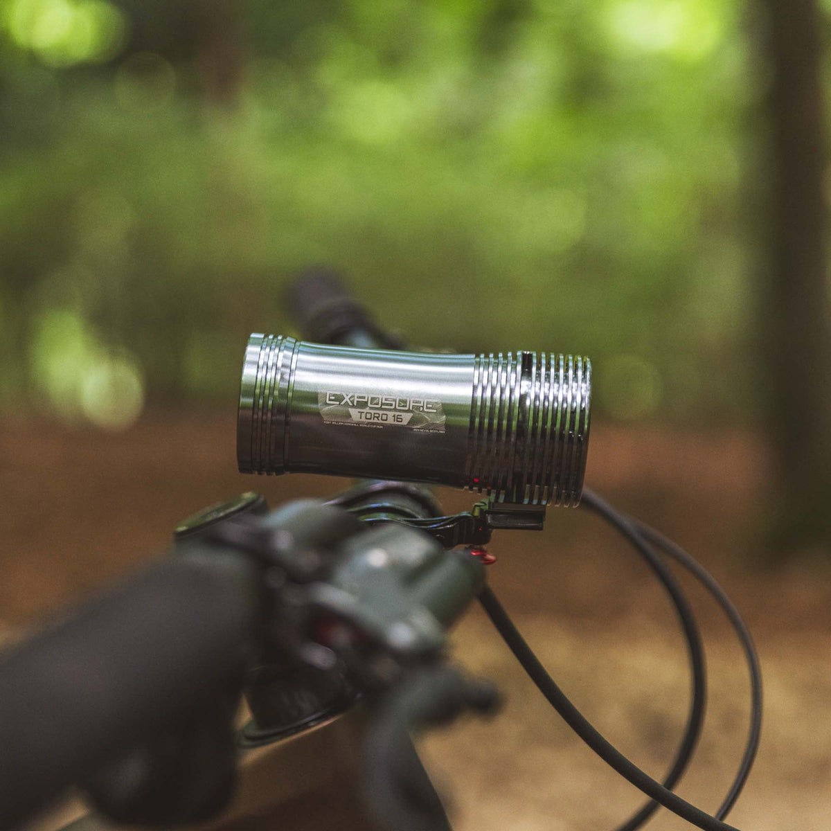 Exposure Lights Toro 16 rechargeable front bicycle light with gunmetal grey CNC-machined aluminium body, 3850-lumen output, colour OLED display and REFLEX 2.0 technology.