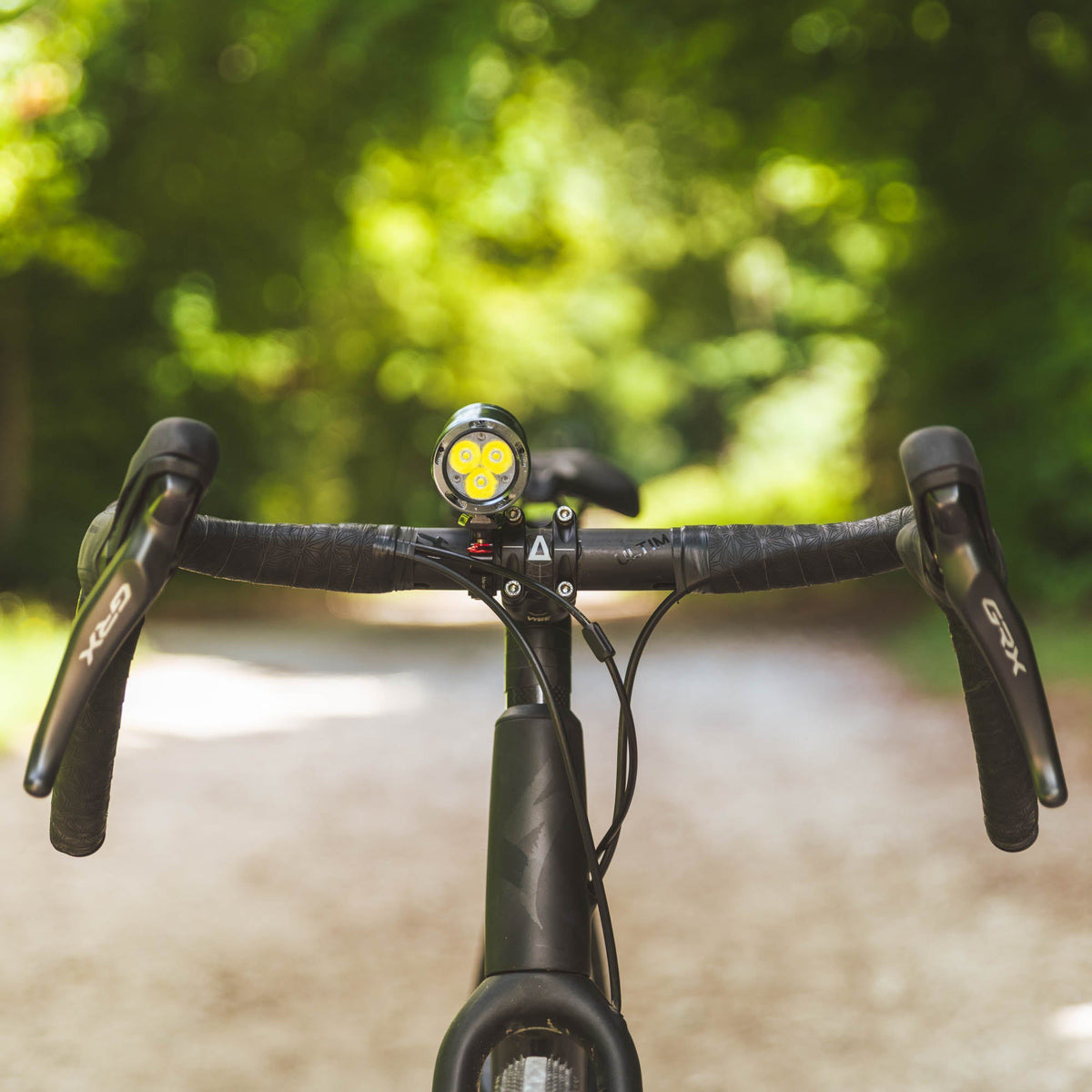 Exposure Lights Toro 16 rechargeable front bicycle light with gunmetal grey CNC-machined aluminium body, 3850-lumen output, colour OLED display and REFLEX 2.0 technology.