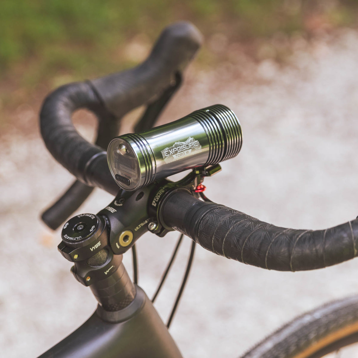 Exposure Lights Toro 16 rechargeable front bicycle light with gunmetal grey CNC-machined aluminium body, 3850-lumen output, colour OLED display and REFLEX 2.0 technology.