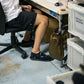 Person sitting on a chair with legs crossed, in an office with a coyote brown Fairweather Dry Sack attached to their desk