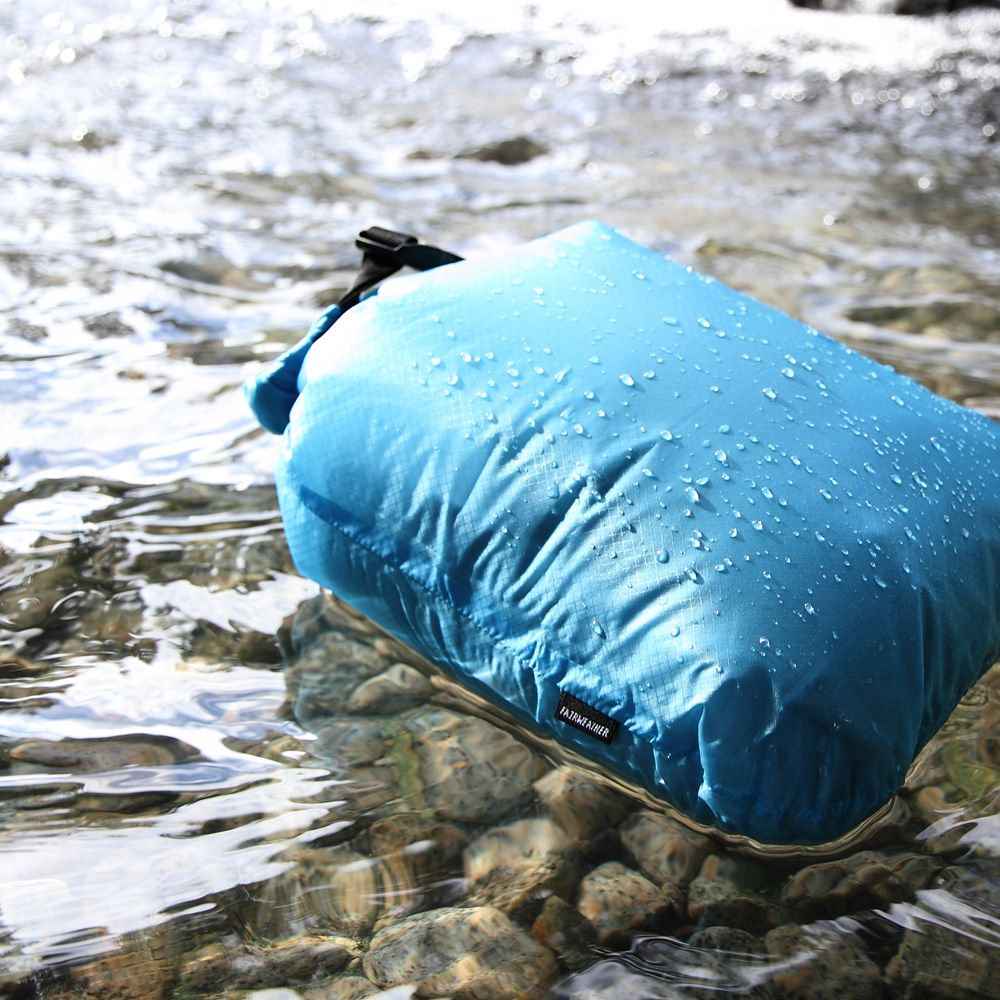A Fairweather Dry Sack in Slate Blue colour, floating on water.