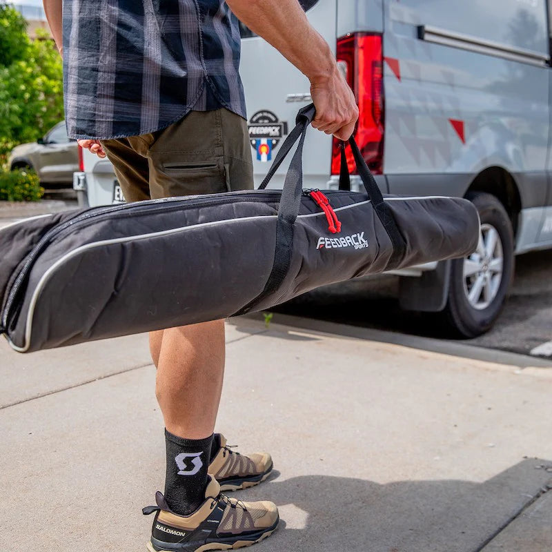Feedback Sports Pro Ultralight bike repair stand packed inside the porter bag and being carried by a human 
