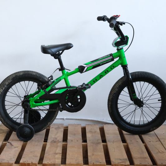 Side view of the green Haro Shredder 16 Kids Bike showing its low stand-over frame, 16-inch knobby tires, and removable training wheels.