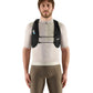 Man wearing a beige cycling jersey and brown shorts with a black hydration pack on a light gray background