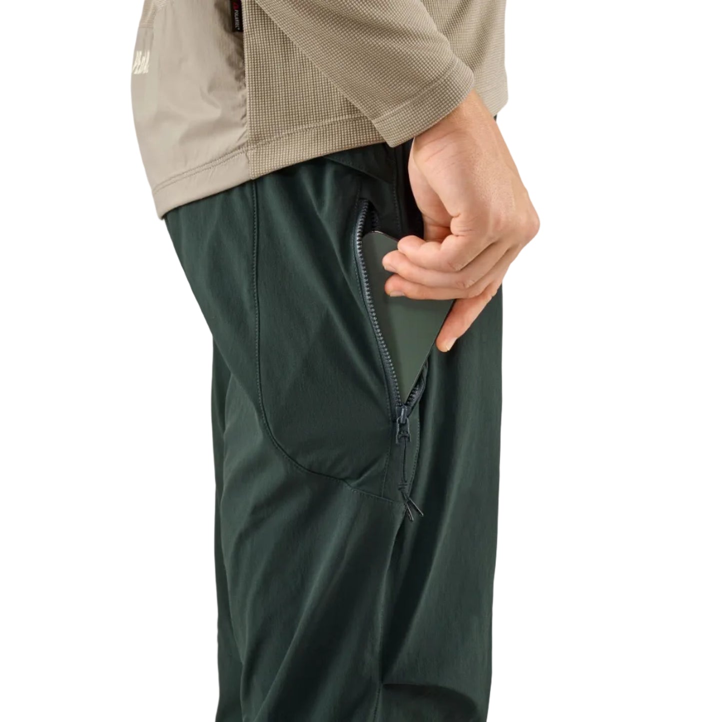 Man putting cellphone into pocket on dark green PeDaLED Yuma Trail Pants for trail riding, bikepacking and adventure cycling
