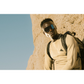 Person wearing Ombraz Refugio armless sunglasses leaning on rocky background
