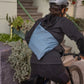 Person riding a bike with a blue smoke musette on his back
