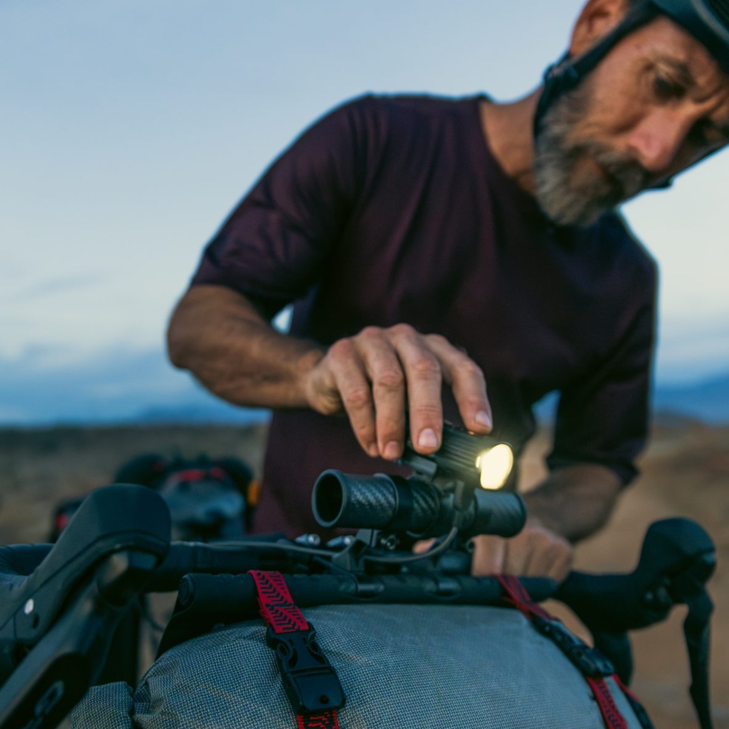 Revelate Designs Hammerhead bikepacking handlebar harness with carbon support tubes, adjustable clamps, Hypalon sling and elevated light and computer mount.