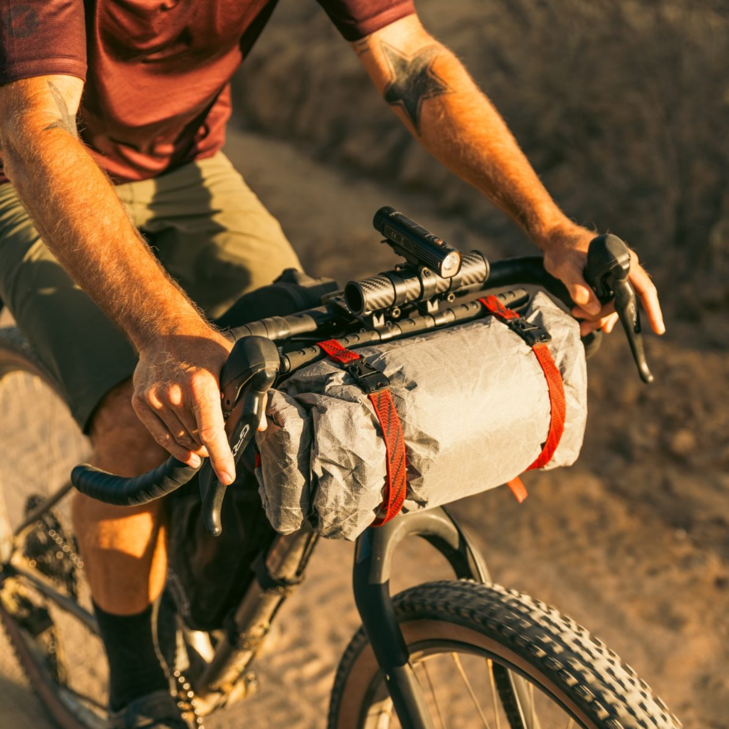 Revelate Designs Hammerhead bikepacking handlebar harness with carbon support tubes, adjustable clamps, Hypalon sling and elevated light and computer mount.