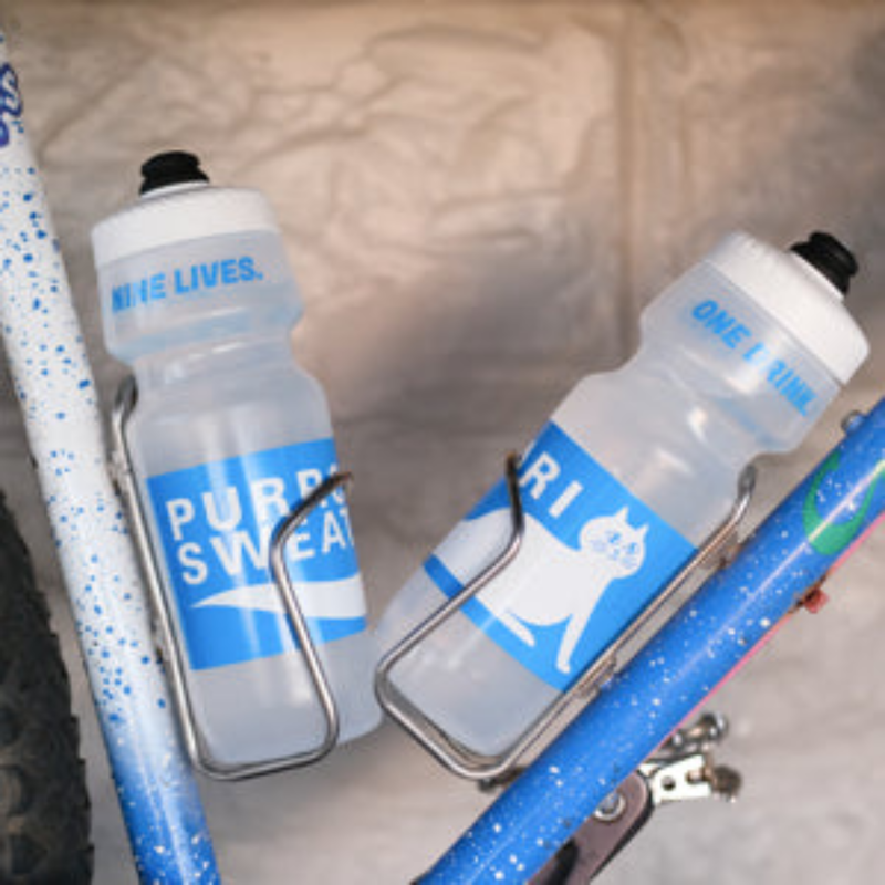 SimWorks Purrcari Sweat 24 oz cycling water bottles in bottle cages mounted to a bike
