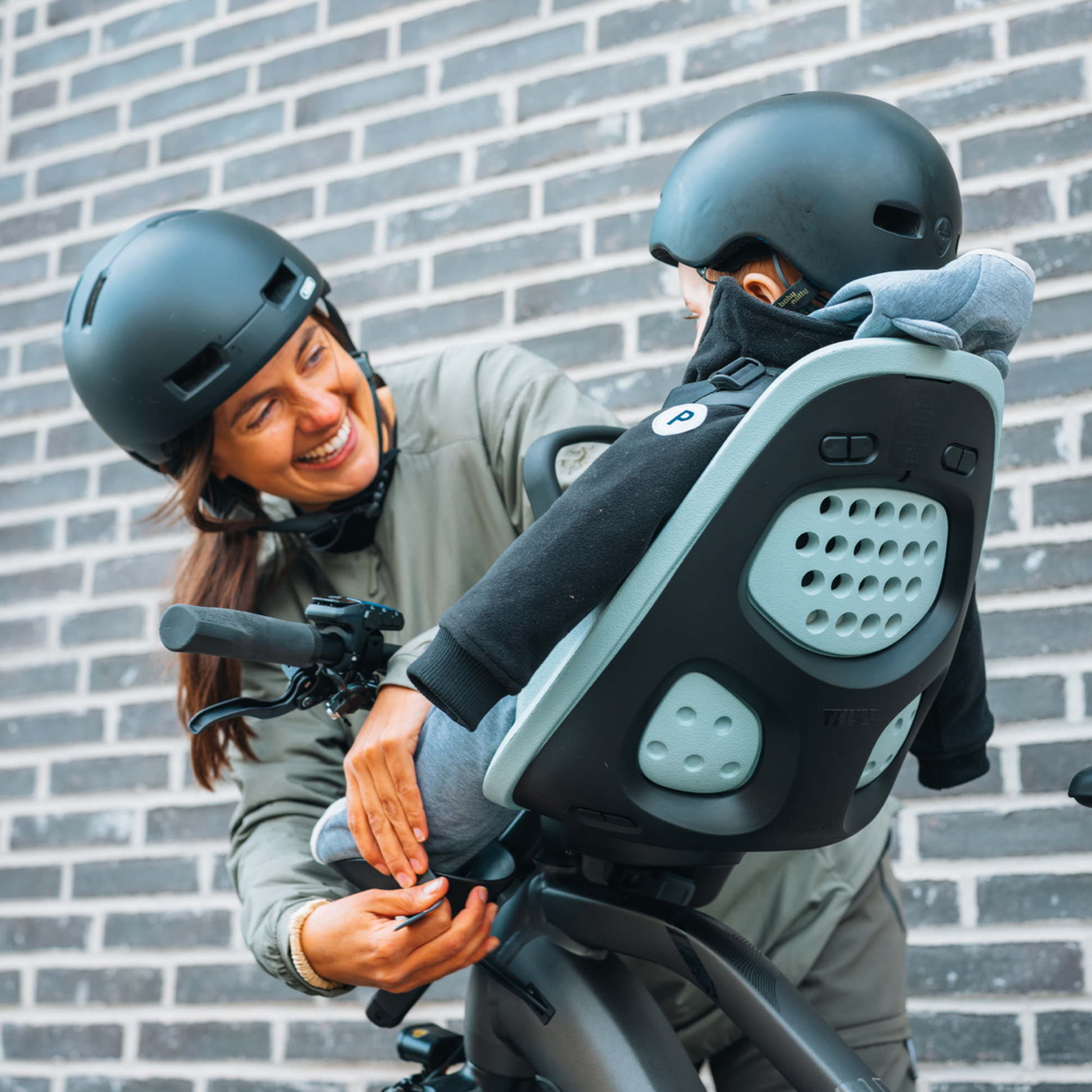 Thule Yepp 2 Mini front child bike seat in Alaska Blue with child being buckled in